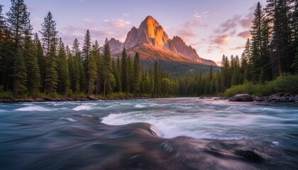 Majestic golden mountain peak illuminated by sunset towers over a dense pine forest and a rushing turquoise river with long exposure motion blur in a wilderness landscape