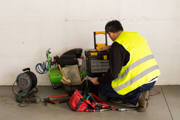 Worker in Safety Vest Handling a Scraper Tool