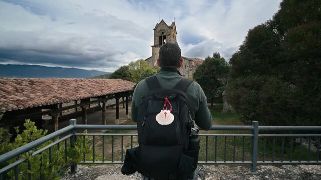 Pilgrim taking a photo of an old church in Frias, Burgos