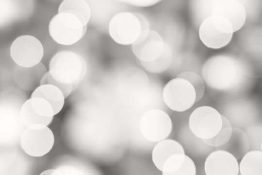 Soft abstract background with bright white bokeh circles in defocused light creating dreamy glowing atmosphere and gentle holiday sparkle for festive decoration, elegant design.
