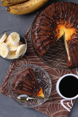 Homemade chocolate cake with cottage cheese and banana filling and cup of coffee, Top view