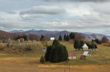 Lonely houses on the background of meadows and mountains rich rural landscape