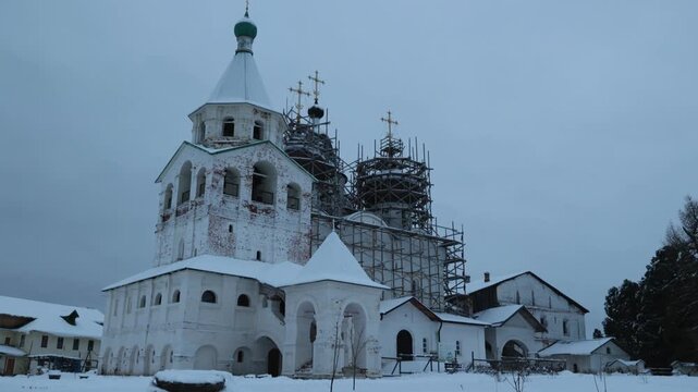 Snow Covered Church Under Scaffolding With Green Dome And Bell Tower, Stone Facade And Courtyard Blanketed