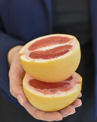 Fresh grapefruit halves in hands