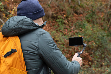 Capturing autumn moments on a trail with a handheld camera setup in the woods