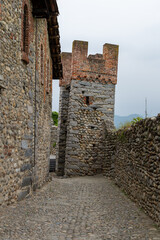 A narrow "rua" (cobblestone street) inside the Ricetto di Candelo, a fortified medieval village in Piedmont.