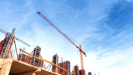 Metal armature on the top of the construction and a crane above. Low angle perspective. Blue sky at backdrop. - Powered by Adobe