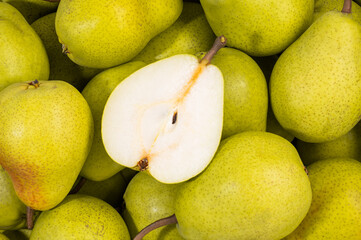 a group of raw ripe pears viewed from above with a slice cut into the center