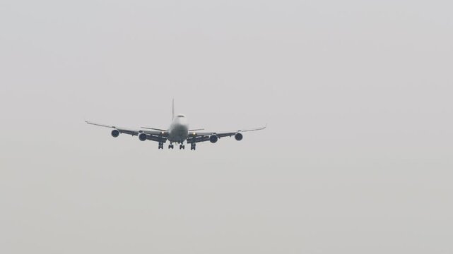 Large cargo aircraft on final approach, front view long shot, set against a clear blue sky. Perfect for aviation, freight, and global transportation themes