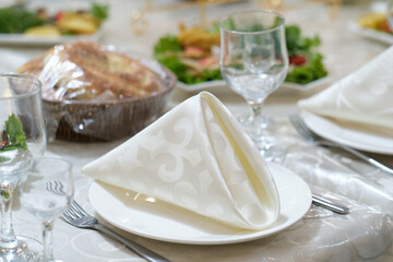 Table set for an event party or wedding reception. Plates and cutlery on table.