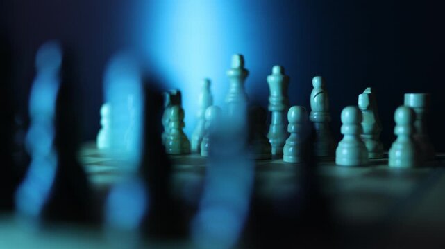 Dynamic video sequence of chess pieces positioned on a slowly rotating chessboard, symbolizing the intellectual confrontation between black and white opposing forces in strategic gameplay. Semi