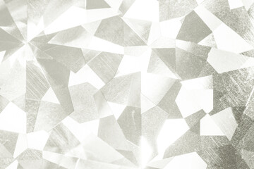 Abstract background surface showing a mosaic of irregular light silver and white geometric shapes...