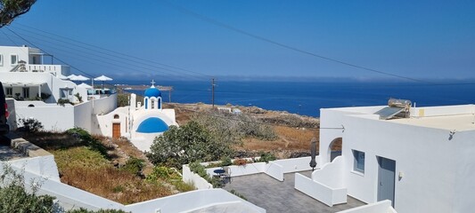 Scenic view of white buildings and blue sea on a sunny day in Santorini