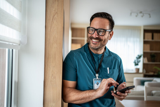 Happy male healthcare professional using phone