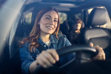 Woman driving car with child in backseat on a sunny day