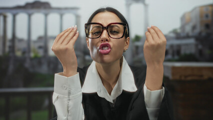 Woman in glasses and judicial robe expresses emotion amidst ancient roman ruins, reflecting tension in a legal context with historical backdrop.