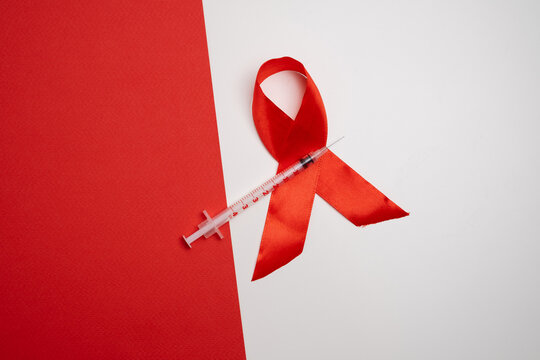  Red ribbon and syringe symbol. Global health awareness.
