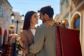 Happy couple in love standing face to face while shopping in the city.