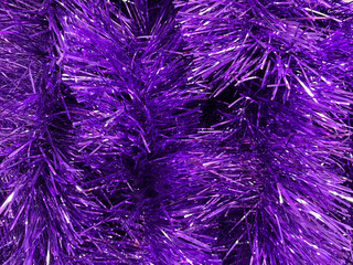 Obraz premium A dense texture of bright purple tinsel filling the frame. A concept of festive decoration, color vibrancy and holiday atmosphere.