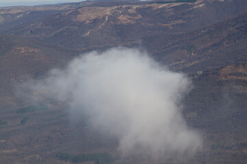 Obraz premium Fluffy white cumulus clouds against deep blue summer sky. Cloudscape view from airplane window. Cloud Dancer - Color of the year 2026.