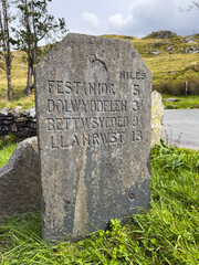 Stone road distance marker in North Wales on A470 highway