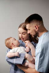Parents happily interacting with their baby during a family moment in a simple indoor setting captured in a bright atmosphere