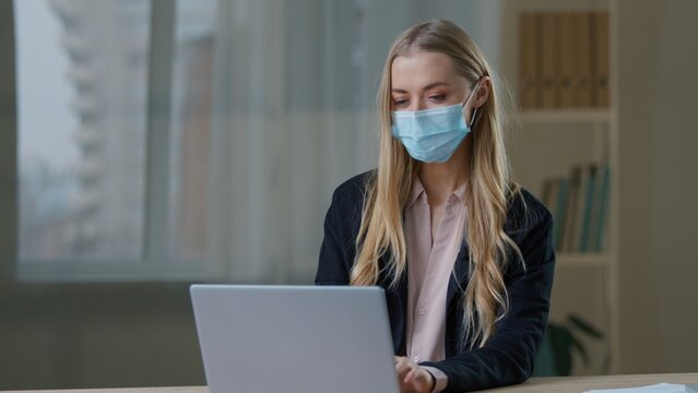 Caucasian business woman in medical mask working laptop in office sick girl businesswoman female chatting online using computer in company epidemic outbreak prevention coronavirus medicine health care