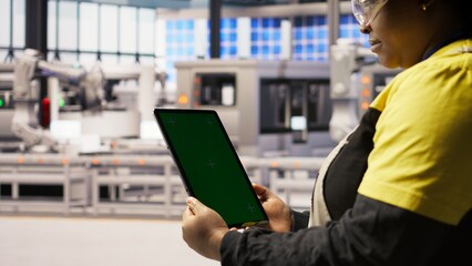 Close up of green screen tablet used by engineer in factory to perform maintenance, analyzing IoT sensors data. Industrial plant worker managing photovoltaic systems using chroma key device, camera A