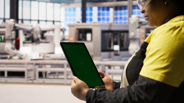 Close up of green screen tablet used by engineer in factory to perform maintenance, analyzing IoT sensors data. Industrial plant worker managing photovoltaic systems using chroma key device, camera A