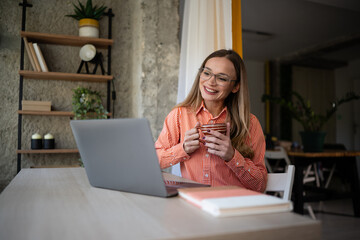 Woman working remotely, smiling enjoying video call