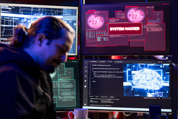 Hacker getting system hacked popup alert on computer display screen after using artificial intelligence malware software. Evil man in underground HQ trying to hide online activity after stealing data