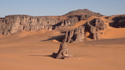 Obraz premium A trip to Sahara desert in Algeria. Beautiful african travel photo. Sandy landscapes, mountains, rocks, dunes, and nature. Summer vacation in arab country.