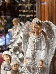 Beautiful white angels, Christmas decorations for sale on a shop window, decorative hand painted ornament in advent market