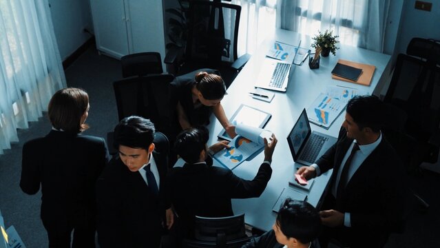 Top view of smart executive manager financial graph to diverse team while group of multicultural business people planning marketing strategy by using stock investment chart at meeting. Directorate.