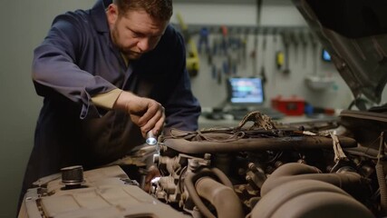 A mechanic carefully inspecting and repairing a car engine in an automotive service workshop Stock Video