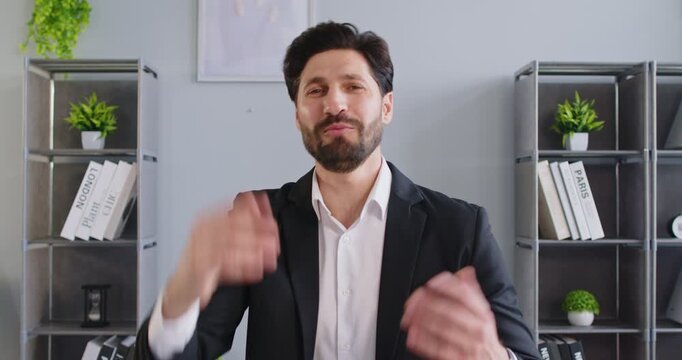 Portrait of positive businessman conducts online video call or conference, talking to camera while working in office, internet communication in a professional space focused on business engagement.