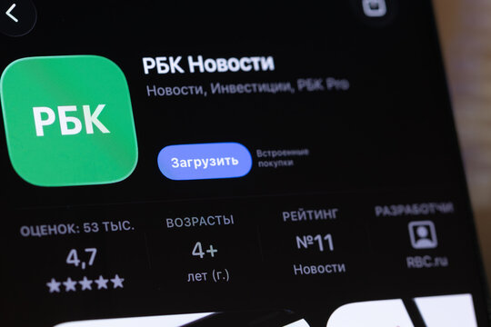 Usinsk, Russian Federation - December 04, 2025: RBK News app interface displayed on a smartphone screen, showcasing news and investment features with vibrant green logo and user ratings