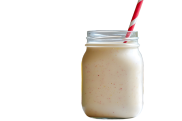 A mason jar of milk shake and bright yellow mango around and a redwhite striped straw isolated on a white background A glass full of fresh tasty and sw