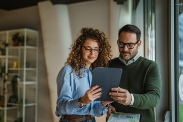 Business colleagues collaborating on project, discussing data in office