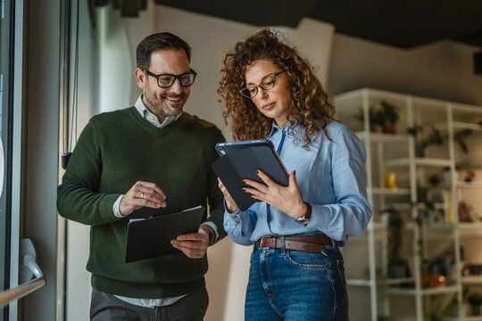 Business colleagues collaborating on project, discussing data in office