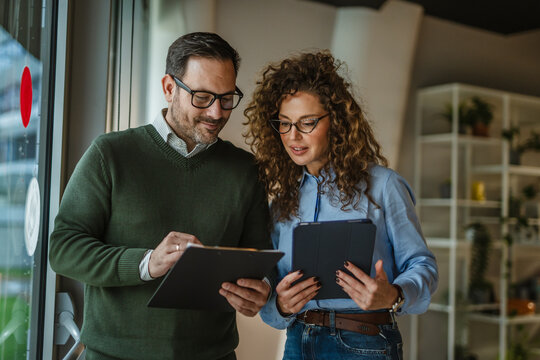 Business colleagues collaborating on project, discussing data in office