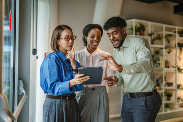 Diverse business team collaborating with digital tablet in office