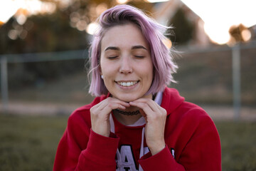 Fototapeta premium Young Adult Woman with Purple Hair Posing in a Grass Field