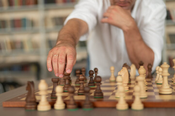 Close up of hands of middle aged caucasian man playing chess. 