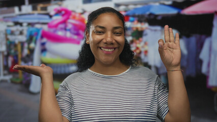 Woman hand makes ok sign with other palm raised while smiling in street market; approval contentment.