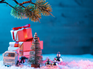 Christmas background miniature with a Christmas tree and a truck with gifts. Copy space
