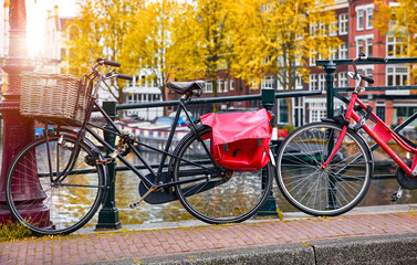 Amsterdam, Netherlands. Bikes over canal Amsterdam city autumn yellow leaf fall. Picturesque town landscape with bicycles with view on river Amstel.