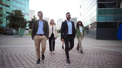 A team of determined professionals walking confidently together through the city, showcasing teamwork and collaboration. The atmosphere is filled with energy and ambition as they stride forward.