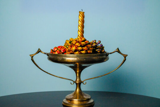 Christmas candelabra with golden candle and pine cones decorated in shades of purple and gold - Powered by Adobe