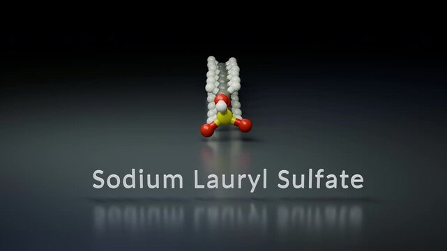 A 3D ball-and-stick model of Sodium Lauryl Sulfate (SLS) is displayed on a reflective dark surface. The structure highlights the long hydrocarbon tail and the hydrophilic sulfate head group.